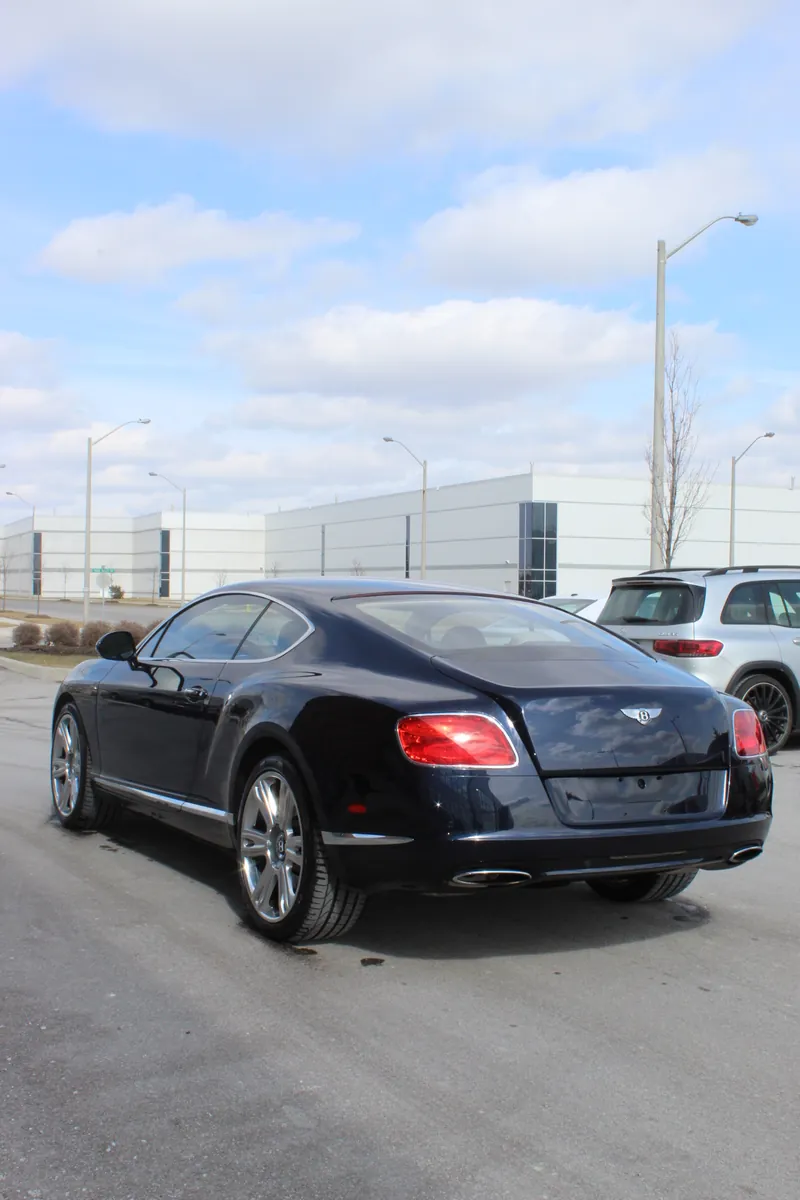 A dark blue Bentley Continental GT with a deep, coated shine