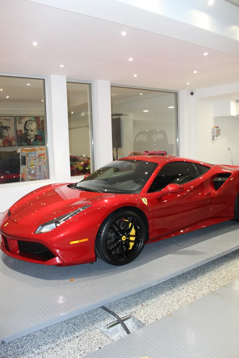 Red Ferrari on a gleaming white garage floor