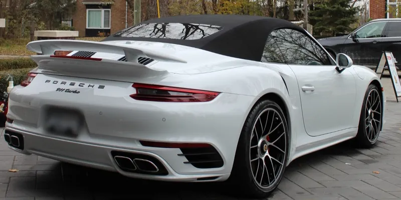 A white Porsche 911 cabriolet with glossy, corrected paint
